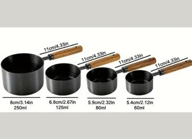 Set of black measuring cups with wooden handles and measurements on a white background